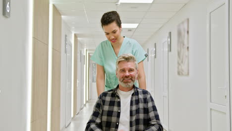 enfermera ayudando al paciente en el pasillo del hospital