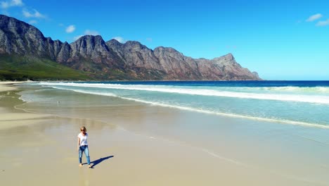 aerial of woman walking on beautiful beach 4k