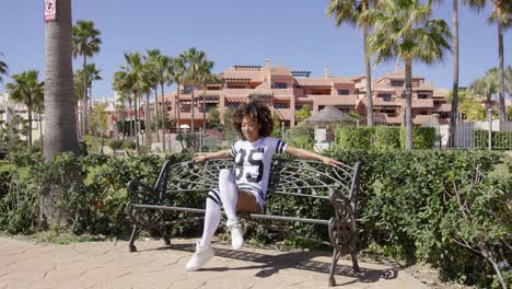 Female-sitting-on-bench-wearing-sporty-outfit