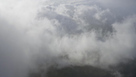 drone dolly view through clouds moving over the landscape of maui in hawaii at daylight