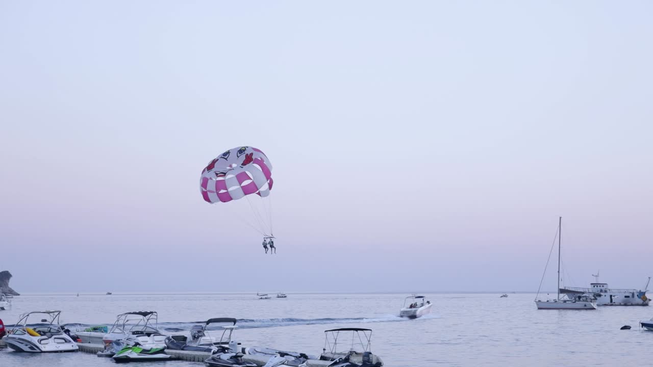 pareja de parasailing en el mar, barco remolca paracaídas