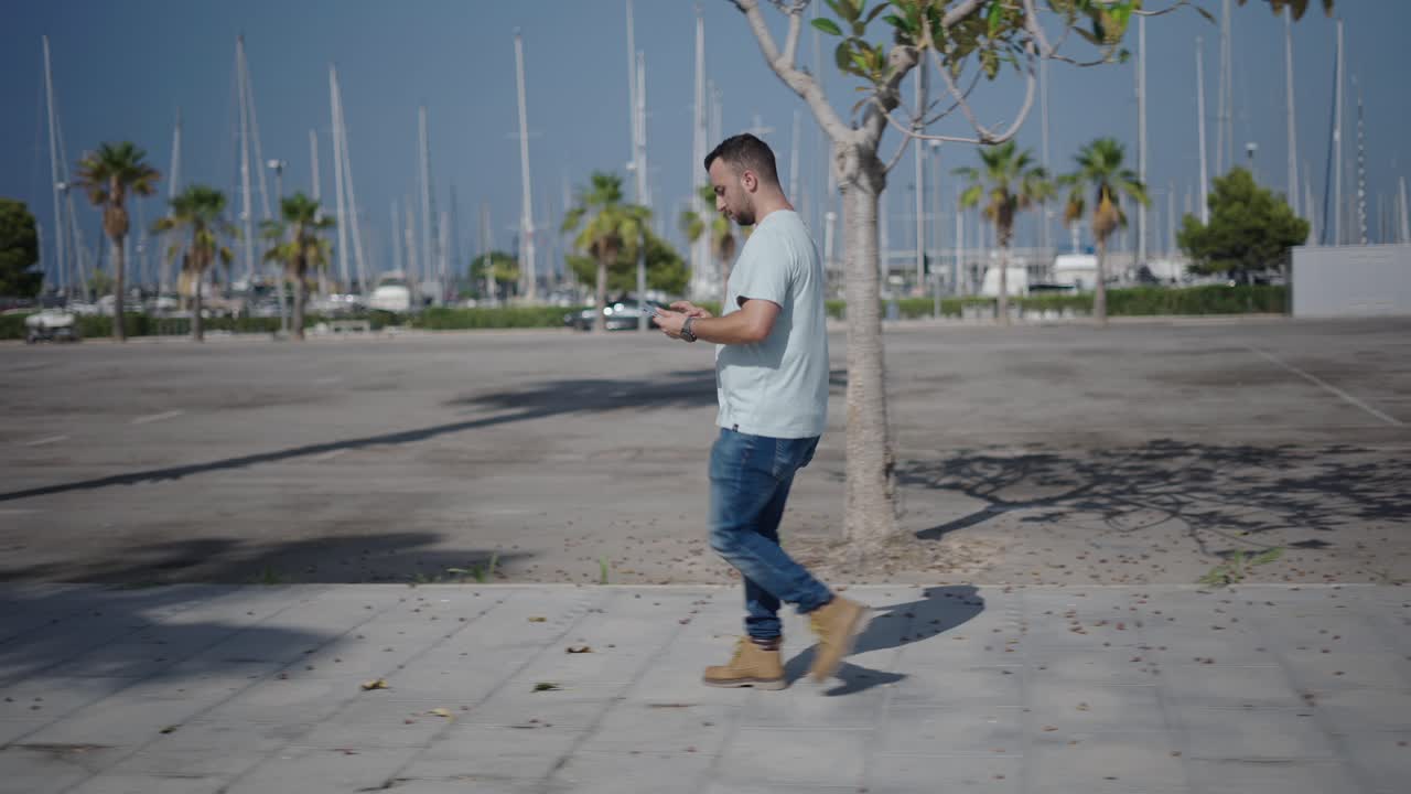 Man Walking with Smartphone in a City Port