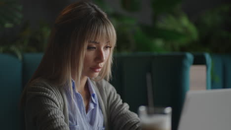 An-Asian-woman-sits-brooding-and-looks-at-a-laptop-screen.-Brainstorm-and-anxious-on-his-face.-Brooding-Asian-woman