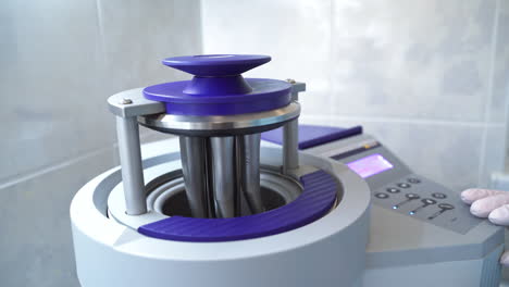 the device lid is going down with the attached dental drilling machine nozzles. modern advanced equipment at work in dental hospital. close up.