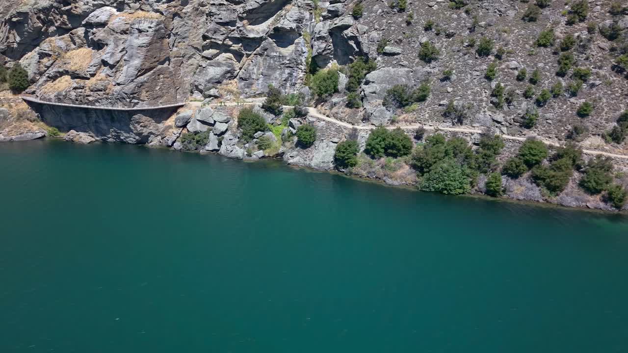 Cycling track along serene Lake Dunstan with historic sights, nature tranquil