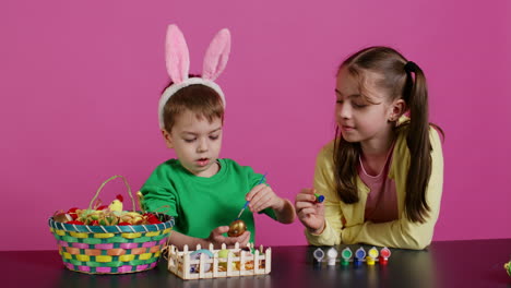 Playful-children-painting-eggs-using-watercolor-and-brushes