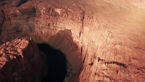 tilt up aerial view of horseshoe bend meander in colorado river canyon, arizona desert and red sandstone cliffs usa