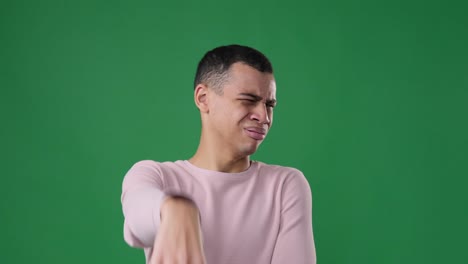 man doing a gesture of disgust over green background