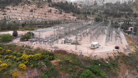 aerial view of an electrical substation in a hilly urban area