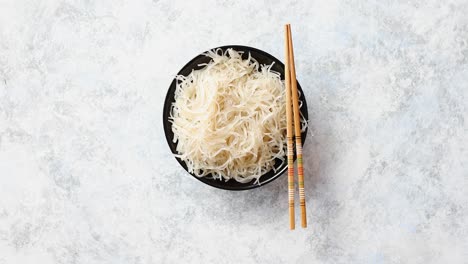 primer plano de tazón de fideos con palillos de madera