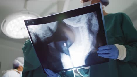 low angle video of two diverse female surgeons discussing x-ray in operating theatre