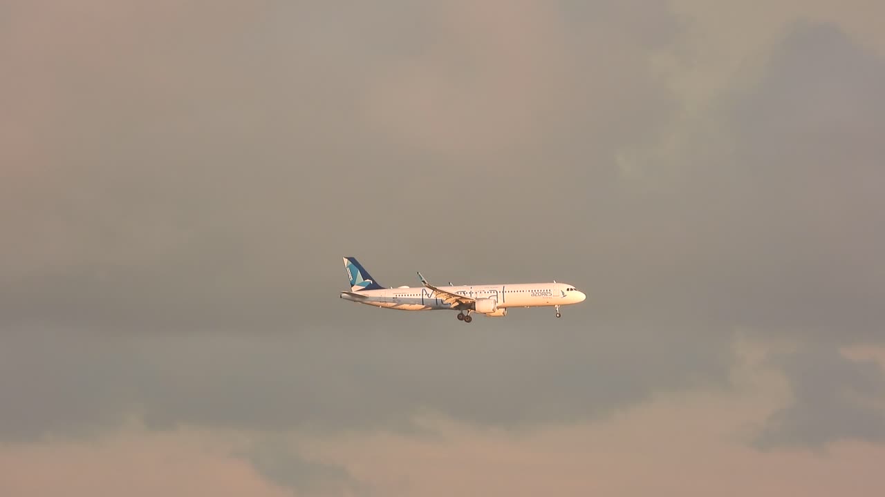 골든 아워 동안 활주로에 착륙을 준비하는 비행기의 측면 전망