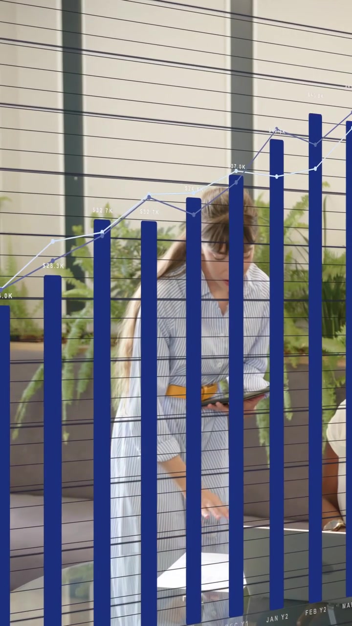 Video verticale: Presentatore che entra, ordina pagine con il telefono per una revisione aziendale, con un'overlay di grafico che copre la scrivania.