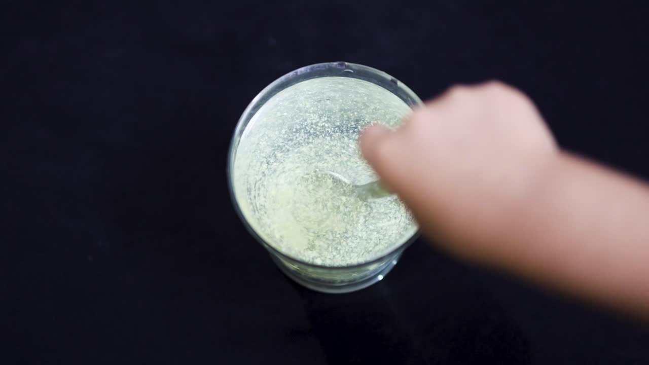dissolving medicine in water glass under indoor lighting