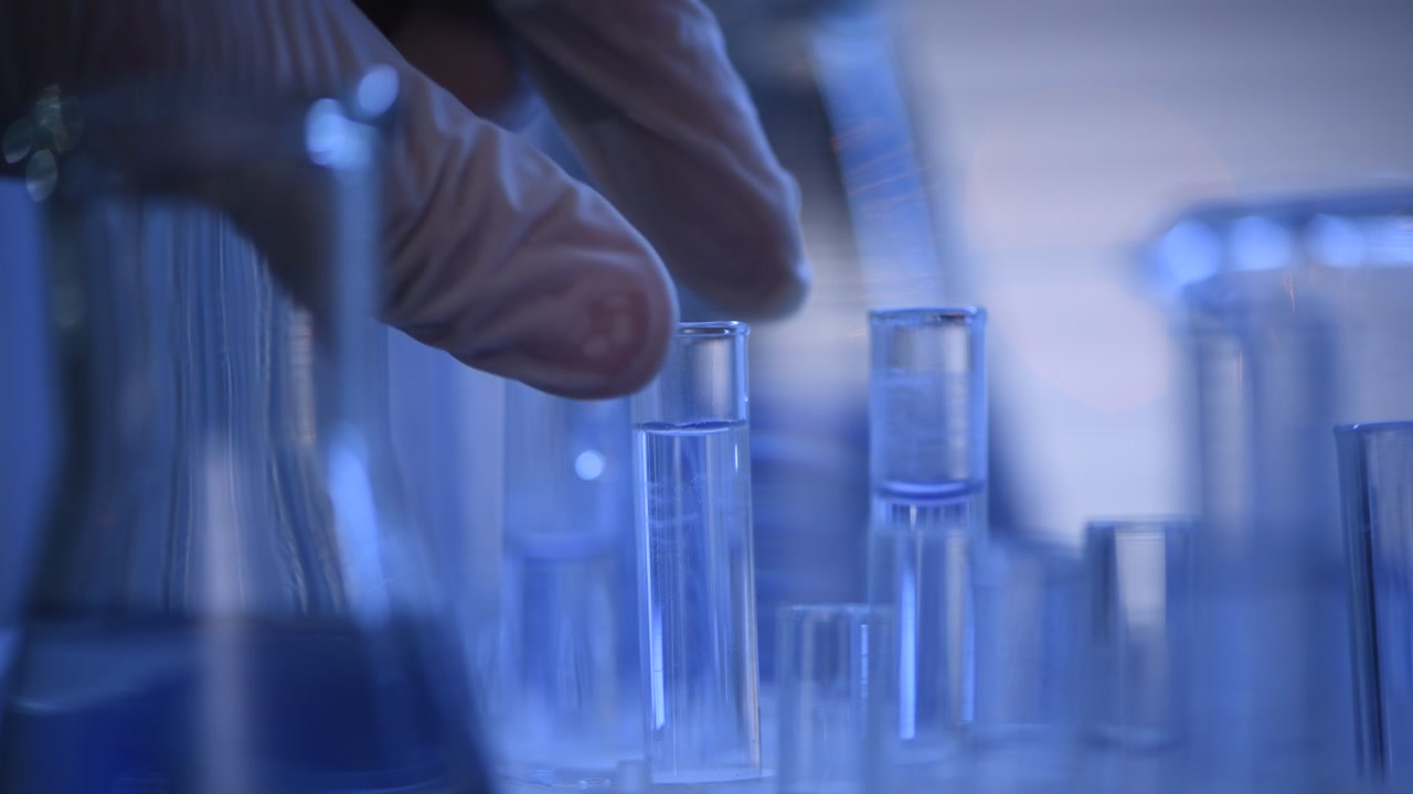 Close-up of Gloved Hand with Test Tube in Science Lab