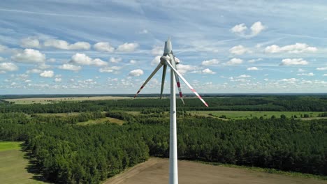 broken wind turbines towering in countryside terrain with dense trees in wiatrak, poland