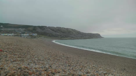 4k cinematic landscape shot of the cliffs of portland, dorset, by the sea on chesil beach on a cloudy day