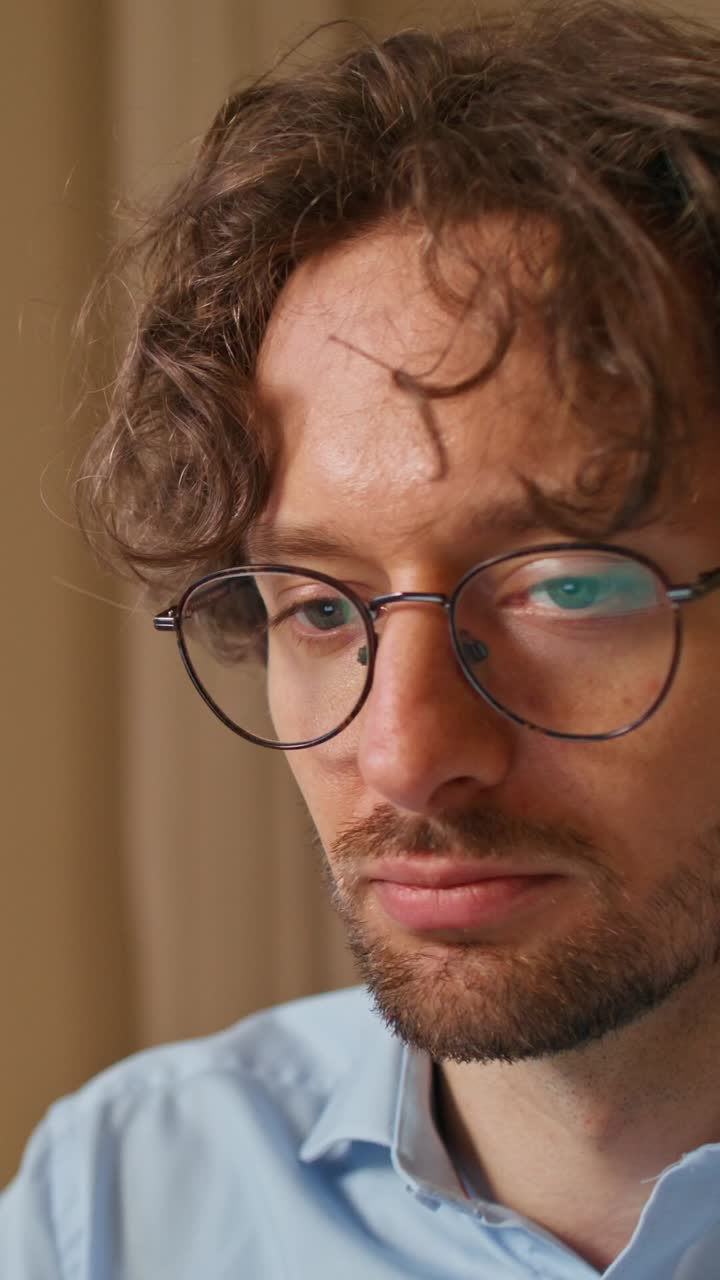 un primer plano de un hombre con gafas y mirando pensativo.