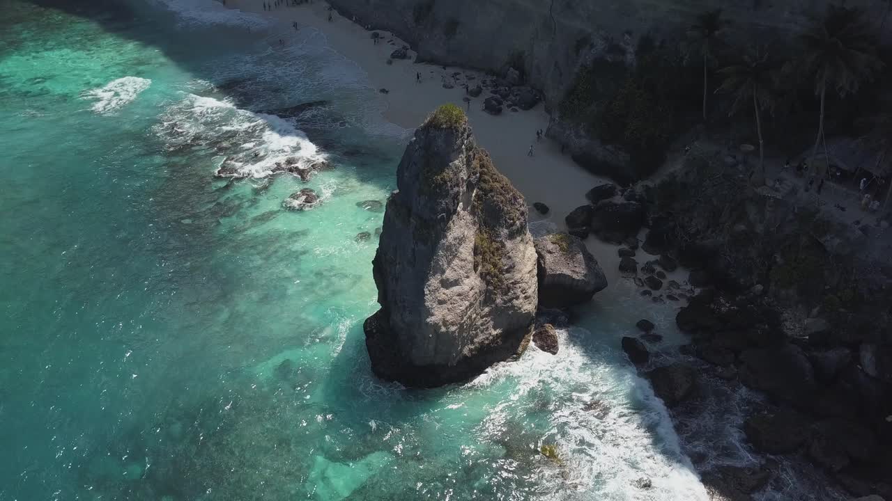 vista aérea del agua azul cristalina de la playa de diamantes en nusa penida, indonesia, con un gran acantilado prominente en primer plano