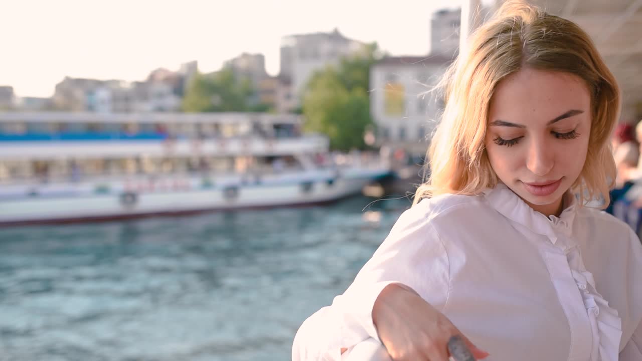 замедленная съемка: красивая девушка наслаждается моментом во время круиза с видом на море на заднем плане