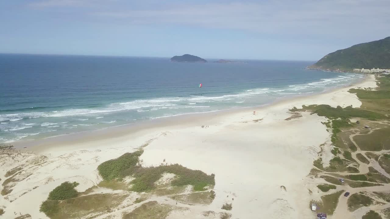 toma aérea del aterrizaje de paramotor en la playa de florianópolis, brasil
