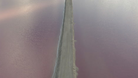 Long-straight-sandy-causeway-between-salt-evaporation-ponds-gone-pink