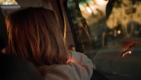 A-Young-Girl-Traveler-On-Road-Trip-Sitting-Inside-A-Car-Looking-At-Street-View-In-Italy