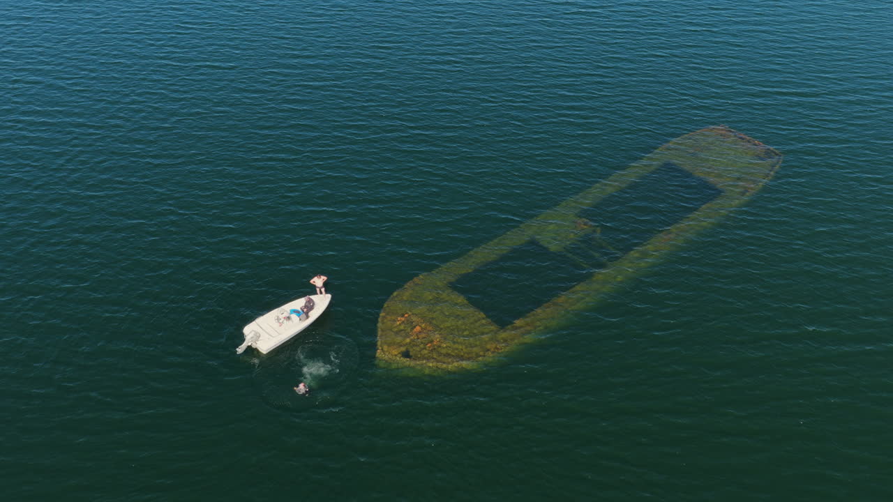 Aerial view of man jumping in the water at a shipwreck on Lake Saimaa, Finland