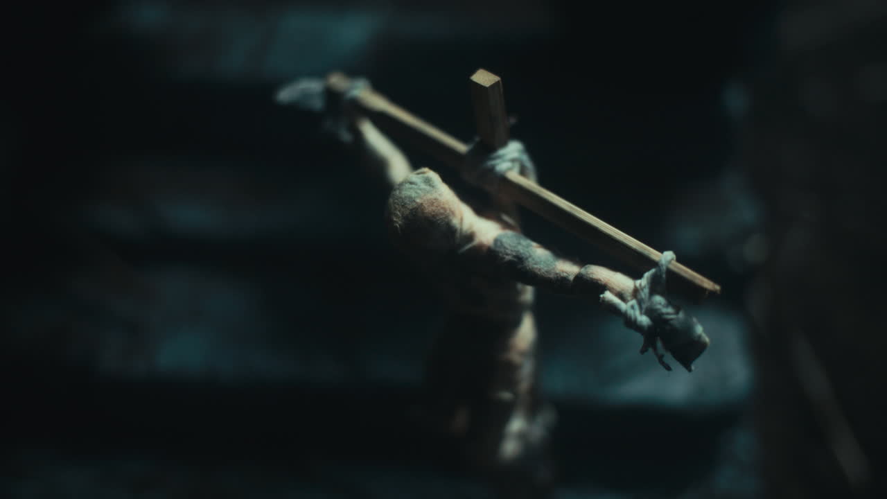 Miniature mummified dolls hanging on the gallows at night