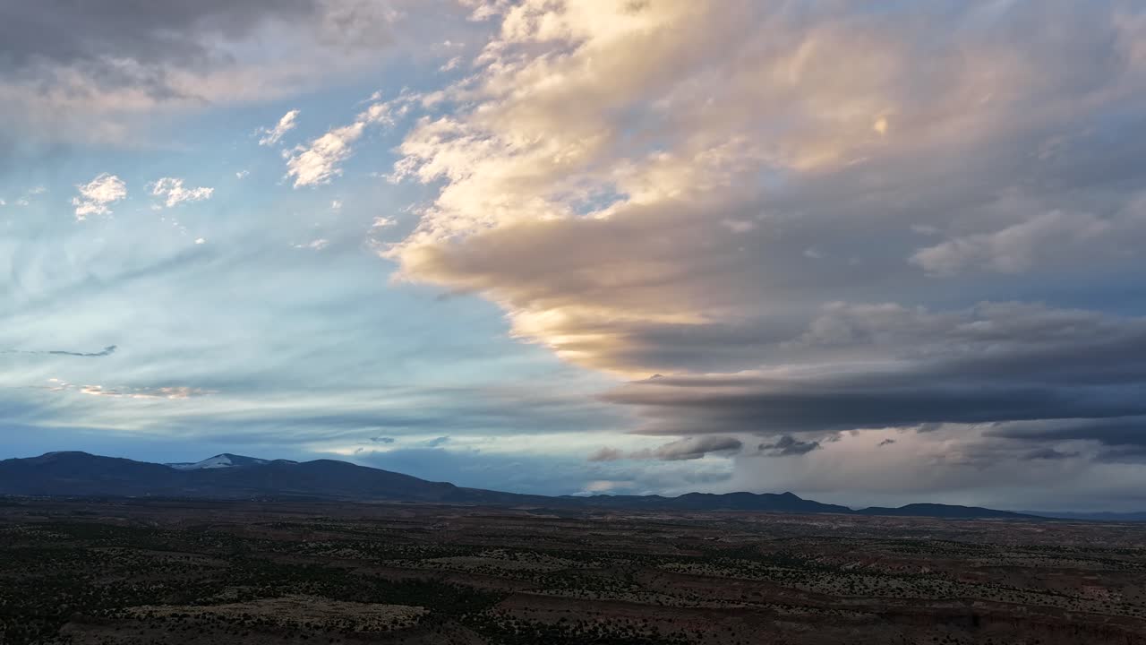 This epic hyperlapse features a stormy sunset sky shifting rapidly above deep southwest mesa plateaus. The vibrant colors and fast-moving clouds showcase the scale of the high desert wilderness
