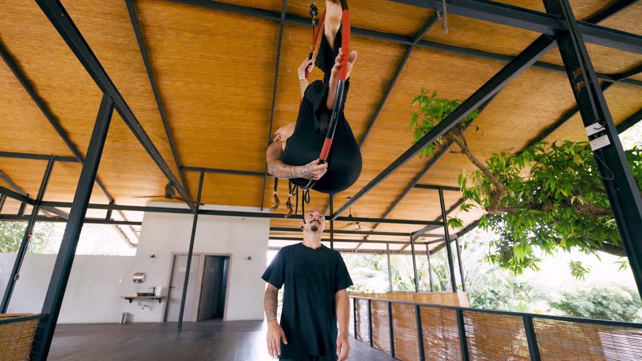 Woman Performing Aerial Hoop Acrobatics with a Spotter in a Studio