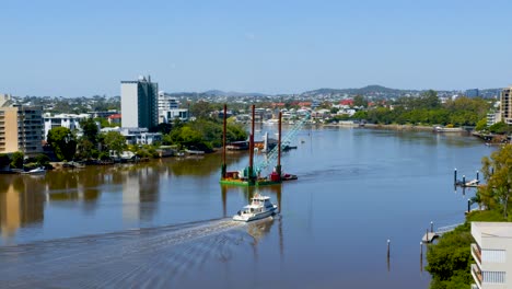 se maniobra una barcaza grúa flotante río arriba para ayudar a reparar los daños de las terminales de ferry y otros pontones que resultaron dañados durante las inundaciones de brisbane.
