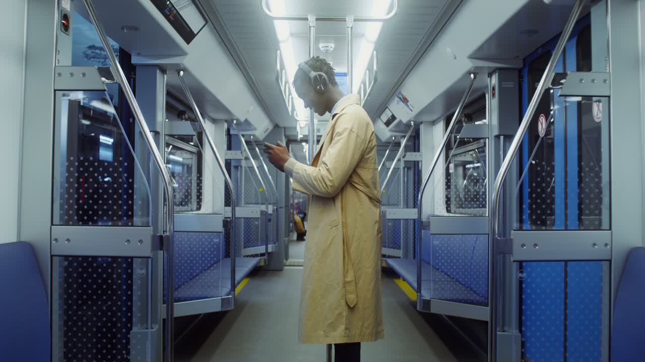 Man on a subway train listening to music