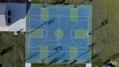 top view of an empty basketball court with multiple baskets for training - pullback drone shot