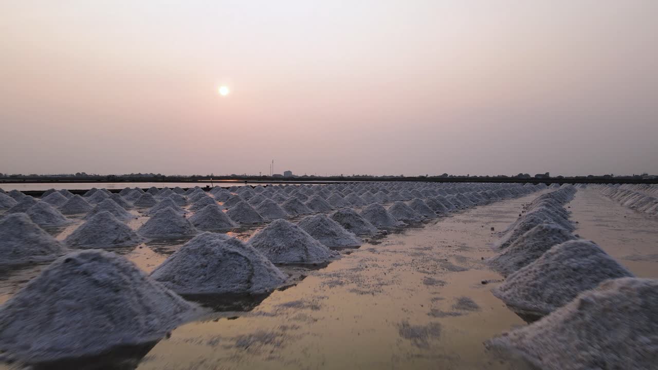 Aerial Drone Over Piles of Sea Salt Ready for Collection with Sunset, Thailand