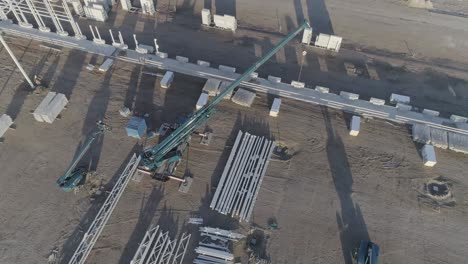 drone shot of crane with material on construction site