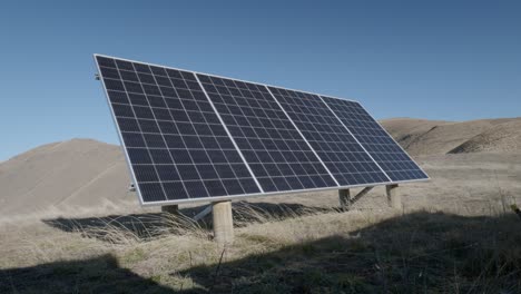 Freistehendes-Solarpanel-Auf-Holzstelzen-In-Sonnigen-Hügeln