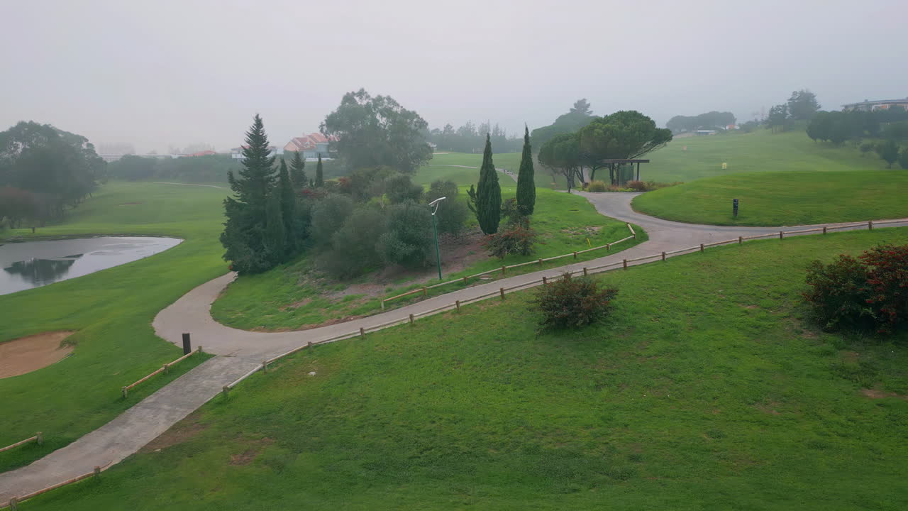 Misty greens golf course stretching at landscape drone shot. fairway