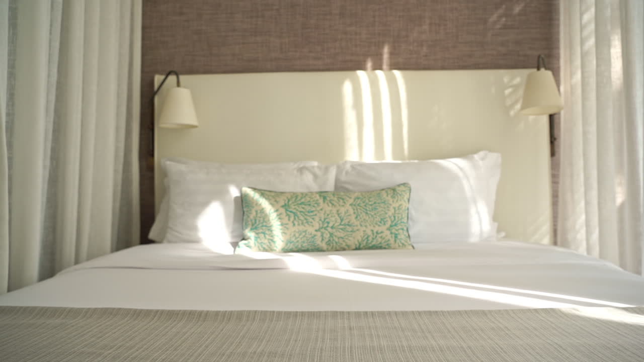 Slow pan from left to right on the made-up bed in bungalow resort in Thailand