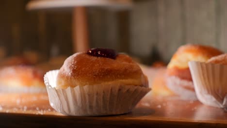 Jam-Filled-Pastry-Donut-On-A-Table,-SLIDE-LEFT