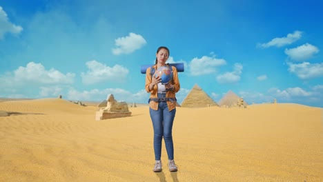 Full Body Of Asian Female Hiker With Mountaineering Backpack Looking At World Globe In Her Hands And Making Confused Gesture While Traveling In Pyramid Of Giza