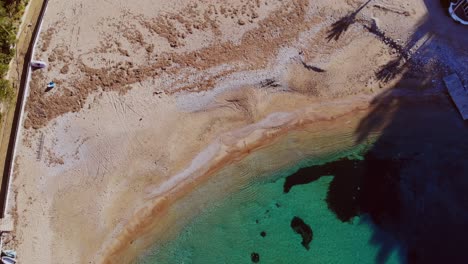 Drone-Adelante-Inclinándose-Hacia-Abajo-Sobre-Una-Pequeña-Playa-En-Ibiza