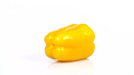 endless loop of a fresh yellow pepper rotating on a white background. side view.