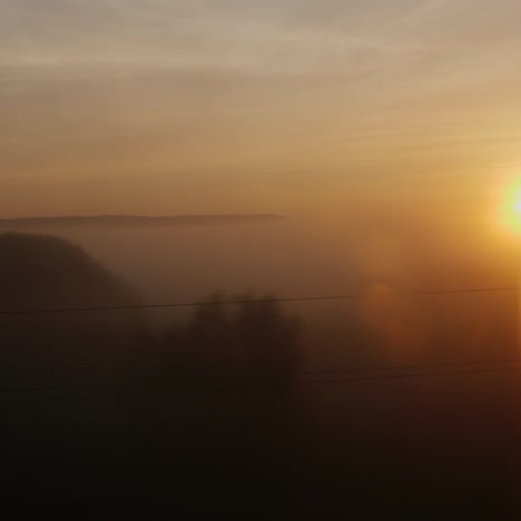 the rising sun from the window of a moving train or car