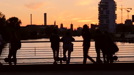 silhouetted tourists overlooking river at sunset