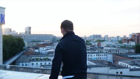 man on rooftop at sunrise