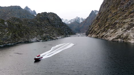 boat speeds along trollfjord - famous tourist attraction in arctic norway