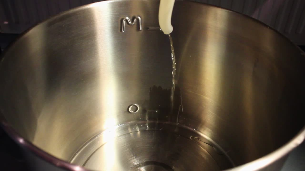 puré de cerveza filtrado en caliente que pasa por una manguera y entra en una caldera de acero limpia