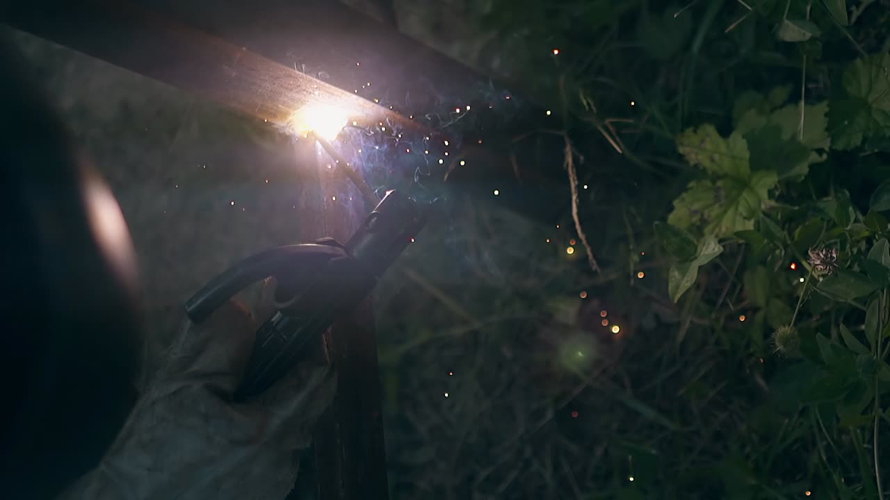 vista de cerca hombre soldas partes de la valla fondo entre los arbustos