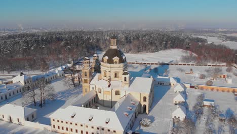 Aerial-view-of-the-Pazaislis-monastery-and-the-Church-of-the-Visitation-in-Kaunas,-Lithuania-in-winter,-snowy-landscape,-Italian-Baroque-architecture,-flying-around-the-monastery,-close-up